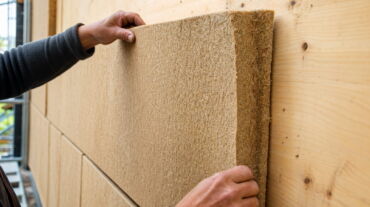 Nahaufnahme einer Holzfaserdämmplatte an einer Hausfassade, natürliche Holzfasertextur, handwerkliche Verarbeitung – holzfaserdämmung – Nørvik Homes